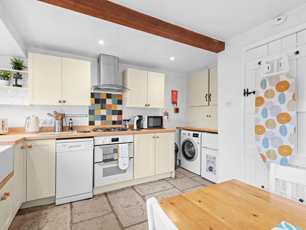 A kitchen with appliances and wooden table at The Old Barn in Manchester