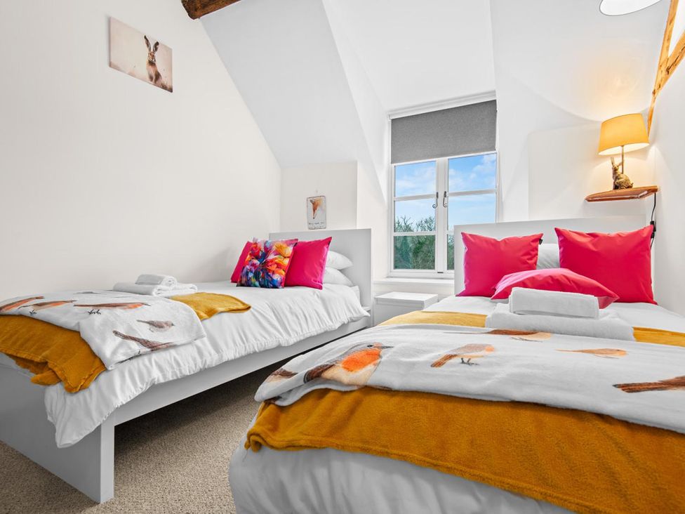 A bedroom with two beds featuring pillows and towels at The Old Barn in Manchester