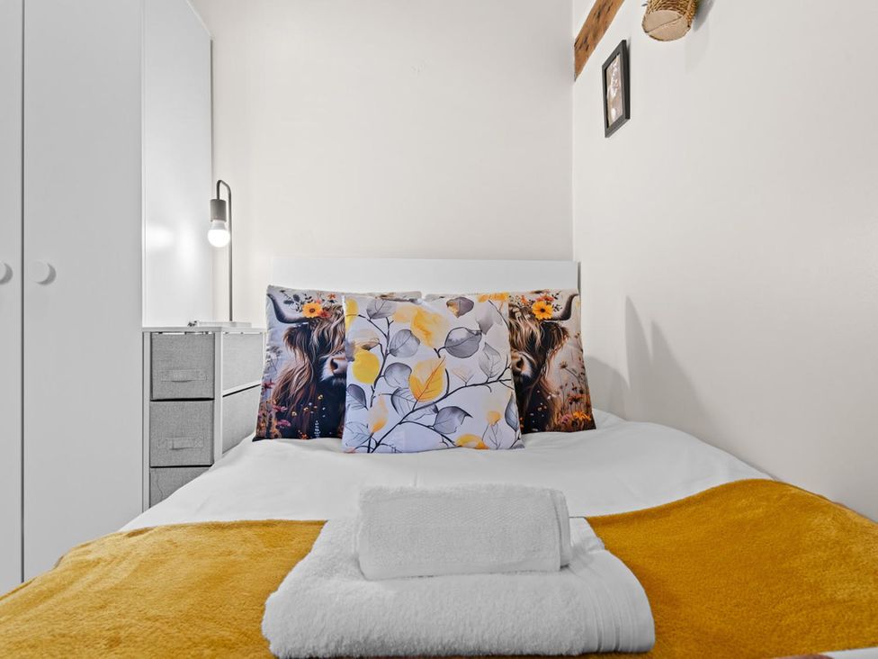 A bedroom with a bed, pillows, and a lamp at The Old Barn in Manchester