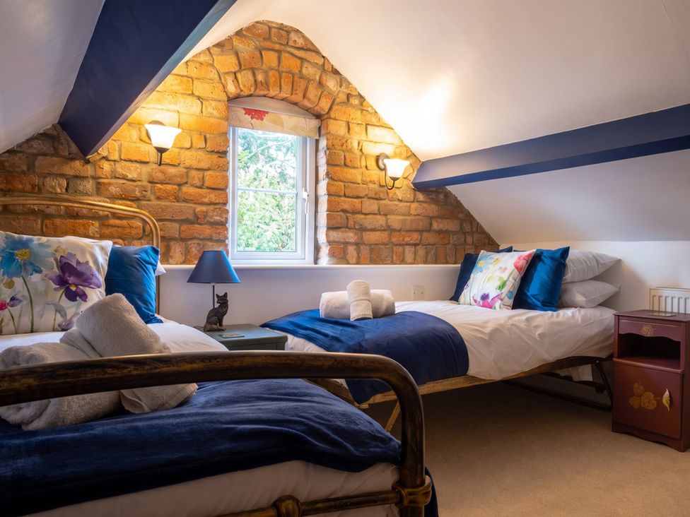A bedroom with two beds, a window, and a lamp at the property in the location