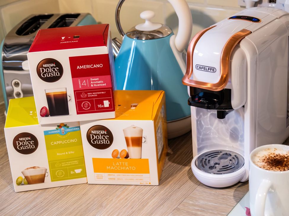 A coffee machine with coffee pods on a countertop in a kitchen