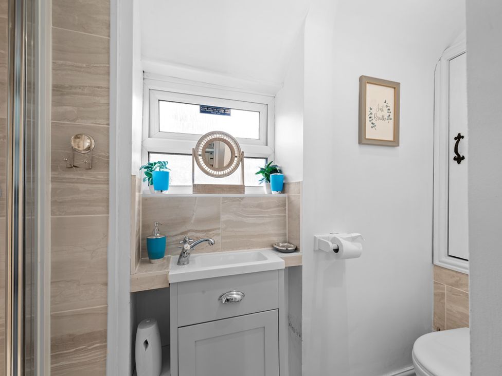A bathroom with a sink, toilet, and mirror at The Old Barn in Manchester