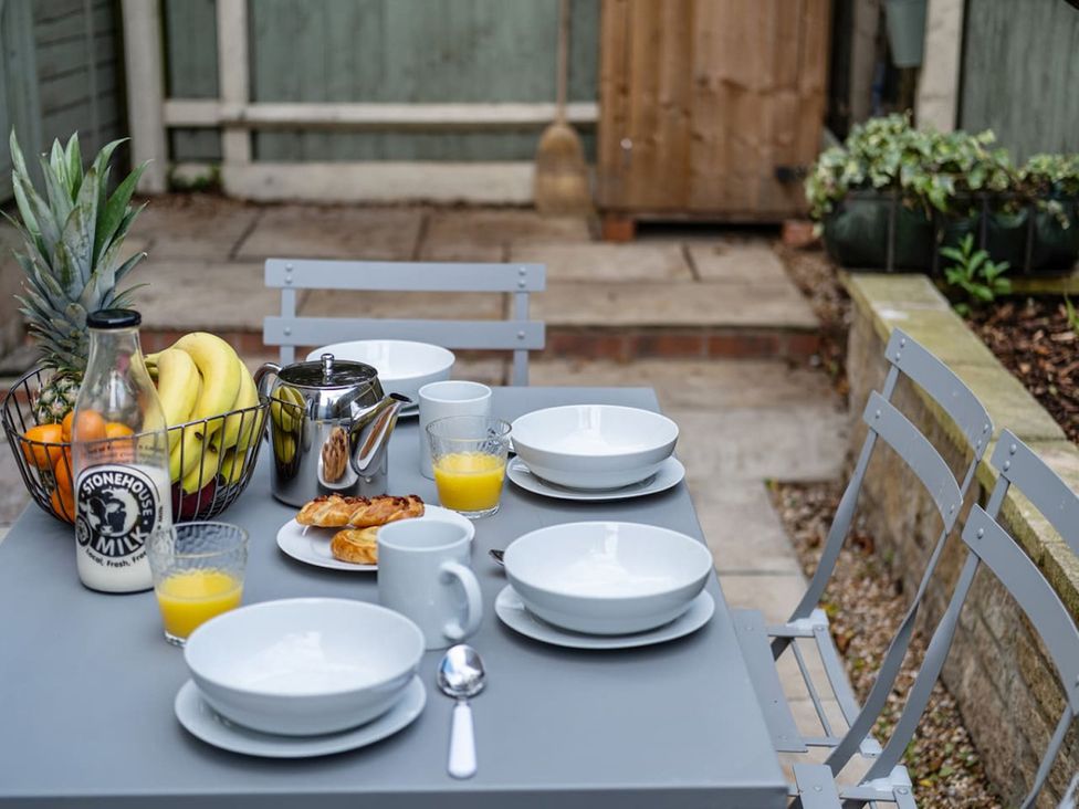 An outdoor dining area with a table set for breakfast at an unspecified location