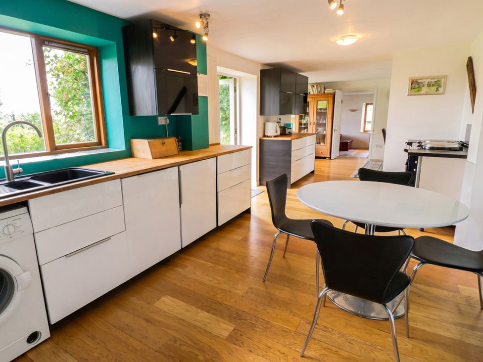 A kitchen with a table and chairs at The Old Barn in Manchester