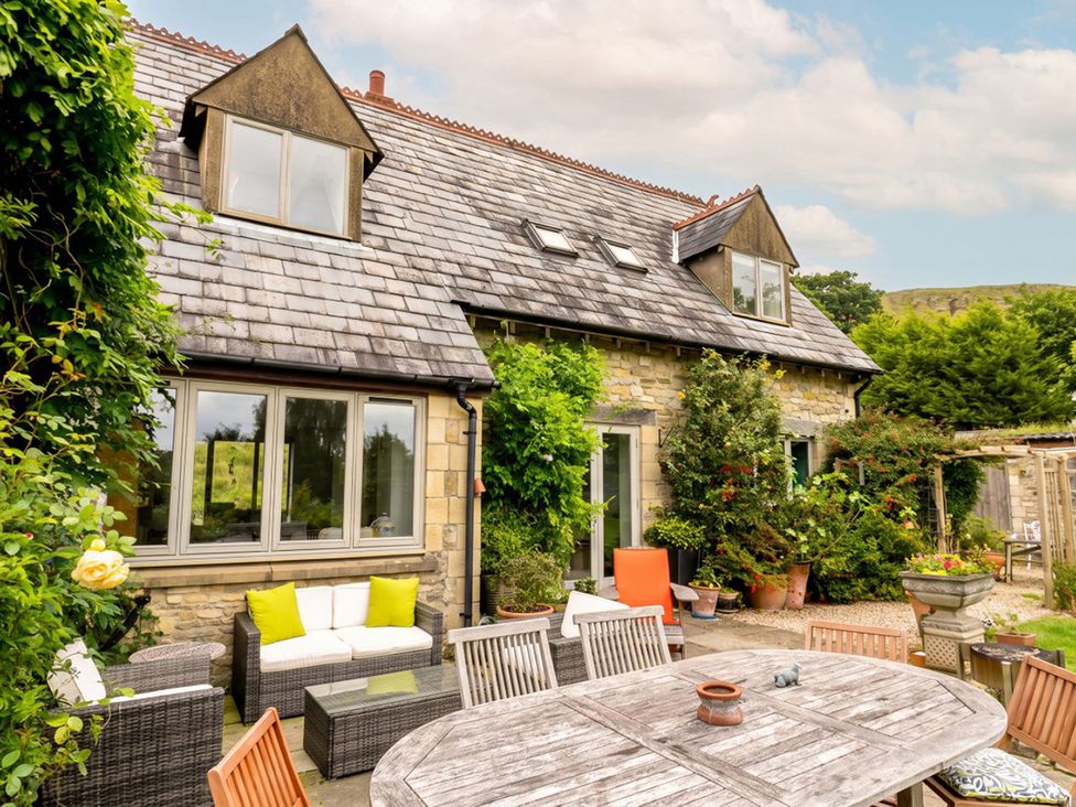 An outdoor area with a dining table and chairs at a stone house