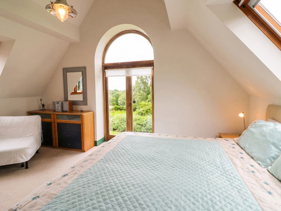 A bedroom with a bed and dresser at The Old Barn in Manchester