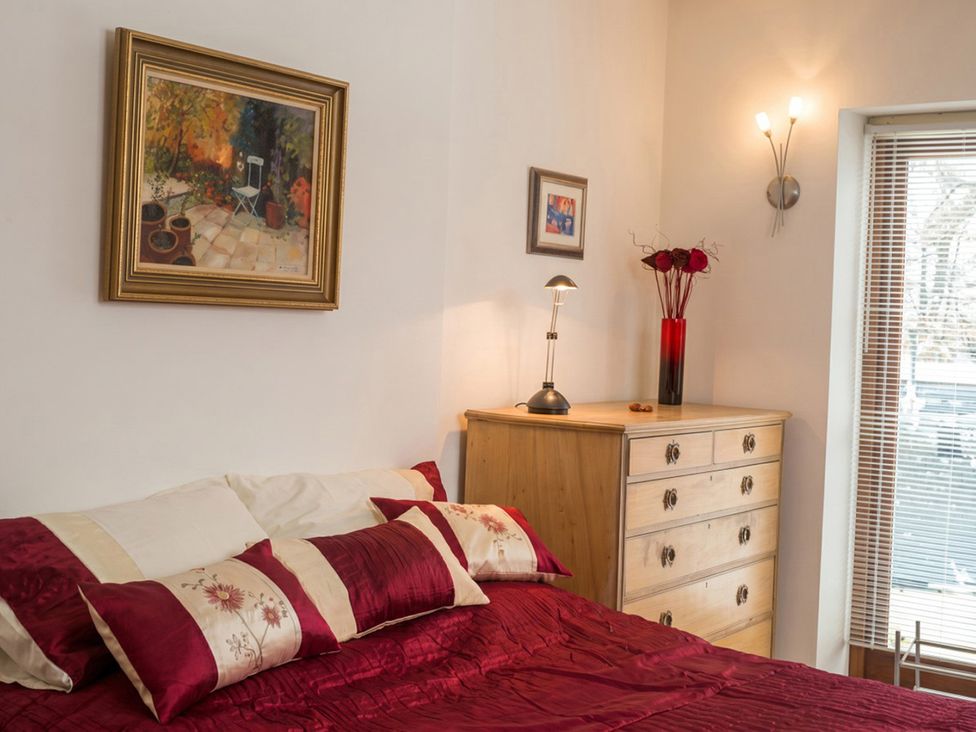 A bedroom with a bed and dresser at The Old Barn in Manchester