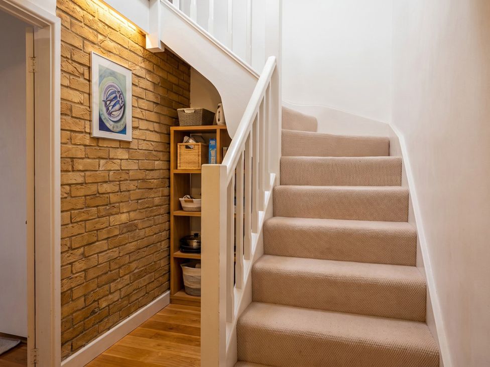 A staircase with a shelf and artwork in a hallway at the property in 
