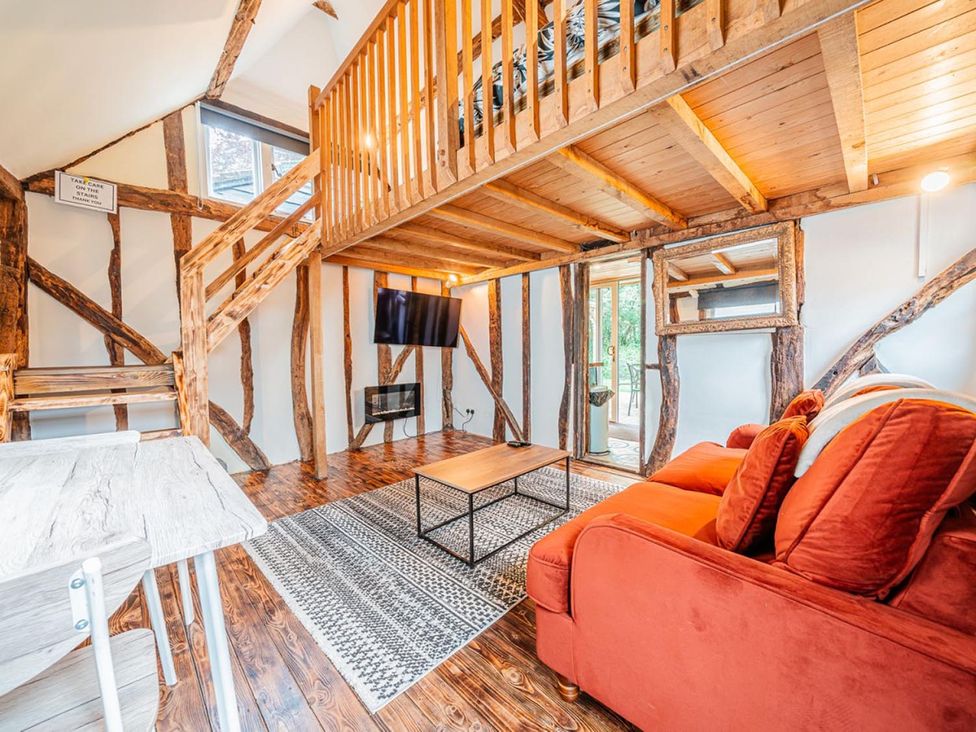 A living room with a staircase and television at an unspecified location