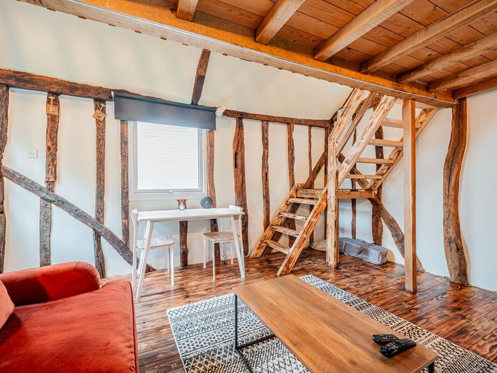 A living room with a table and chairs and a staircase at The Old Barn in Manchester