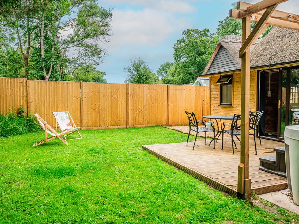 A garden with a deck, table and chairs at The Old Barn in Manchester