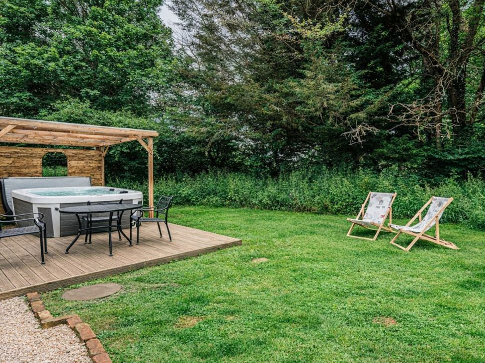 A garden with a hot tub and chairs at 
