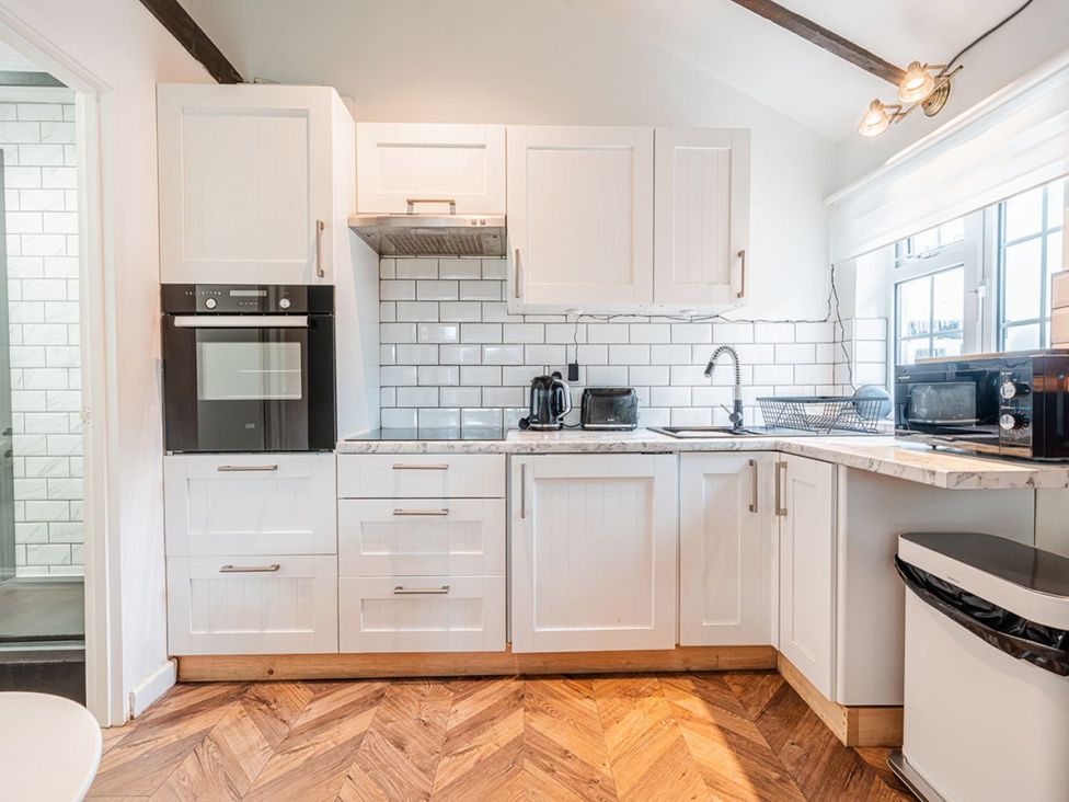 A kitchen with cabinets oven microwave and sink at The Old Barn in Manchester