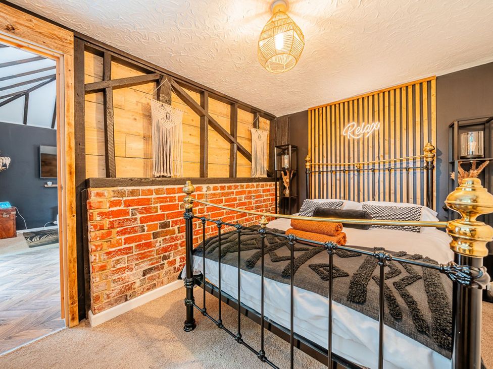 A bedroom with a bed and neon sign at 