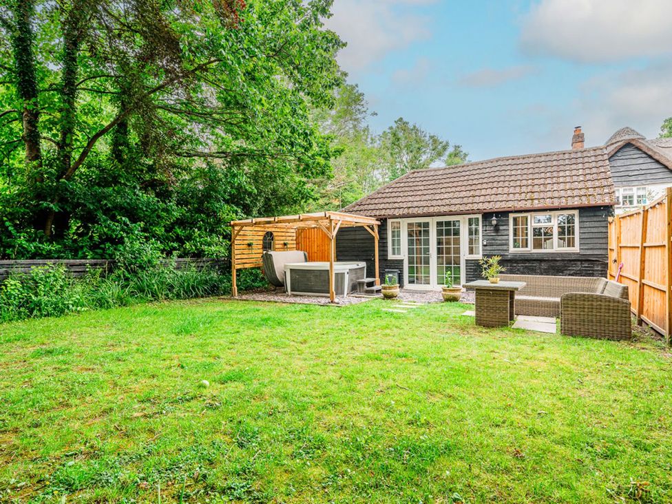 A garden with a hot tub and seating area at the property