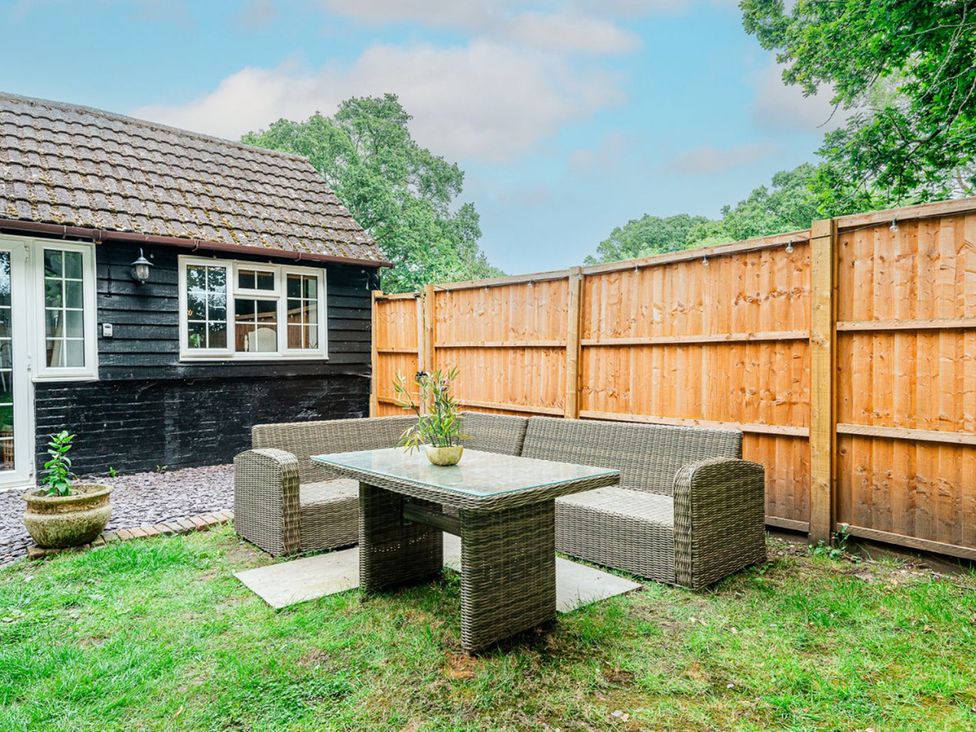 An outdoor seating area with a table and sofa at The Old Barn in Manchester