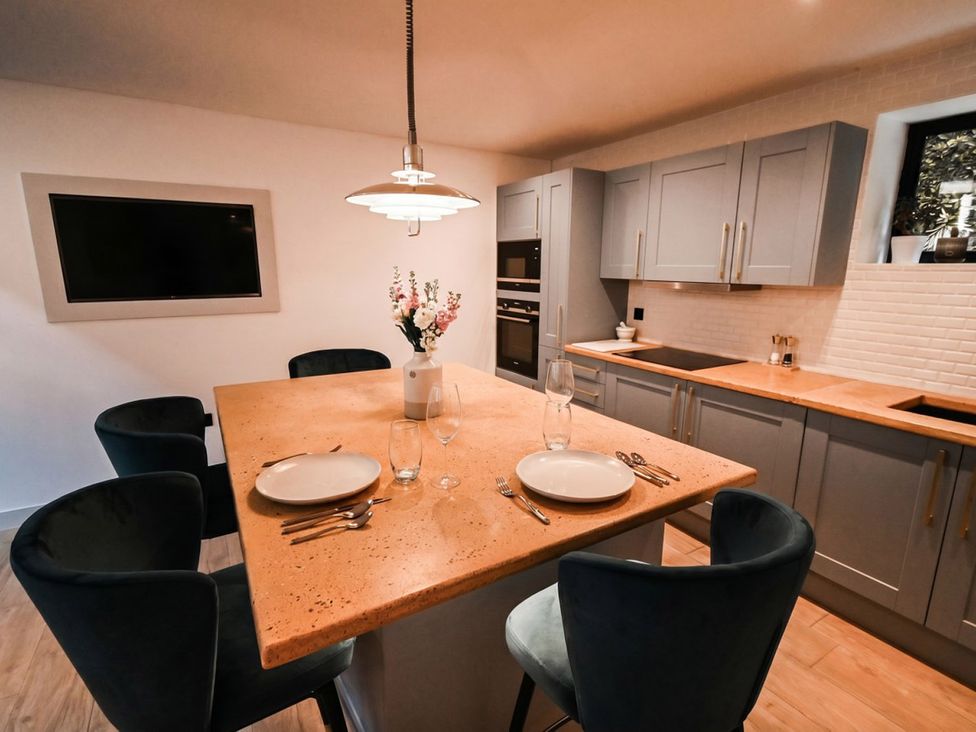 A kitchen with a dining table and chairs at Emery Street Lodge