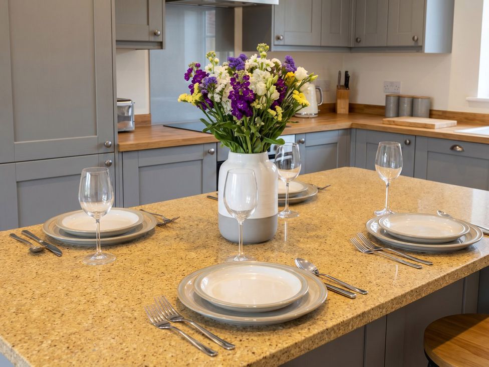 A kitchen with a dining table set for four at Emery Street Lodge
