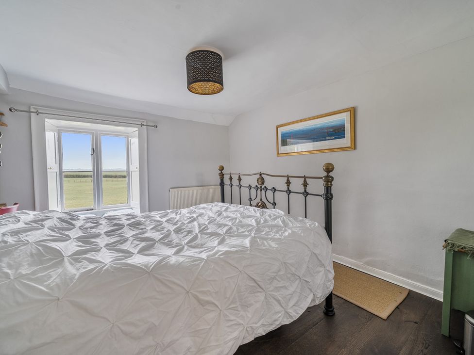 A bedroom with a bed and window at Furzen Farmhouse