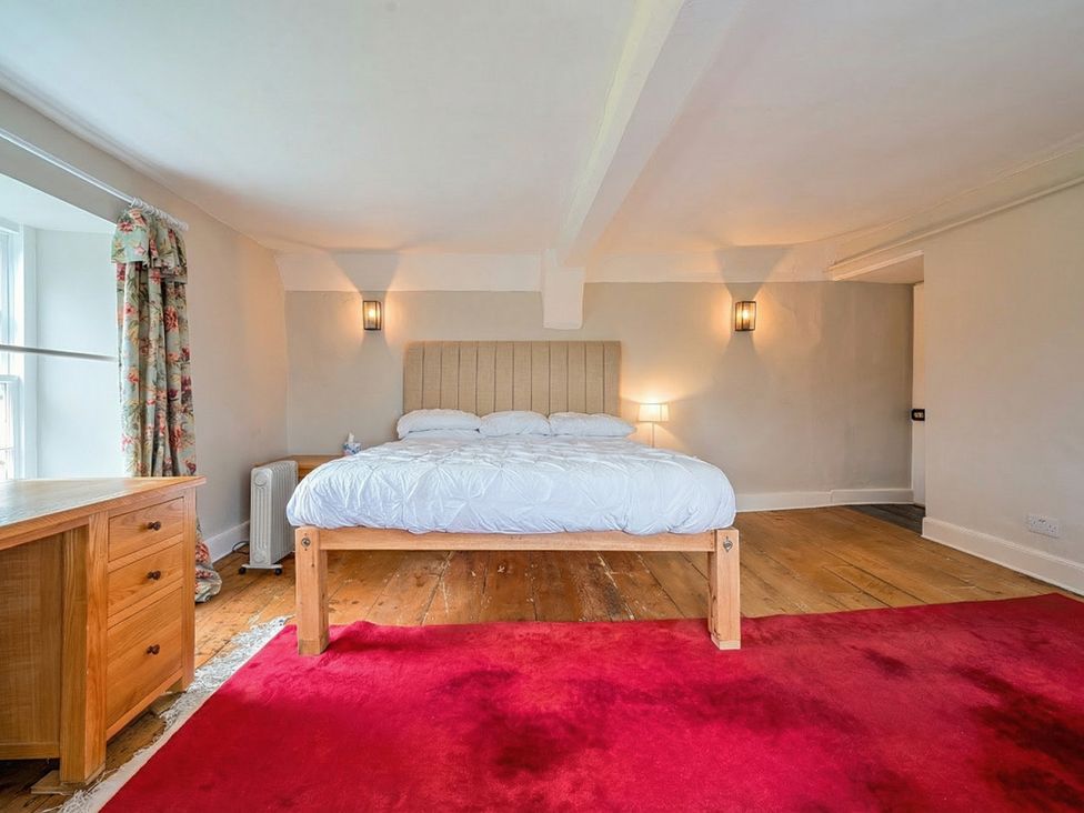A bedroom with bed and dresser at Furzen Farmhouse 