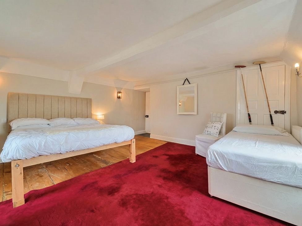 A bedroom with beds and a chair at Furzen Farmhouse
