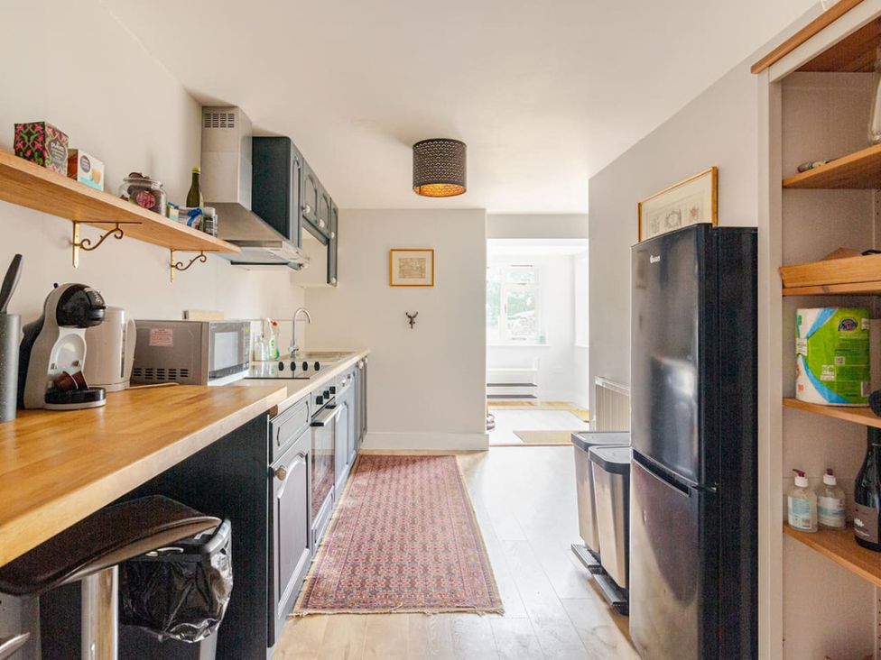 A kitchen with appliances and furniture at Furzen Farmhouse