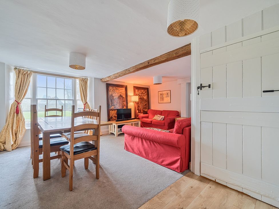 A living room with a table and chairs and a sofa at Furzen Farmhouse