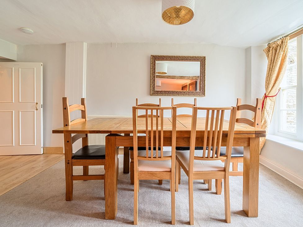 A dining room with a wooden table and chairs at Furzen Farmhouse