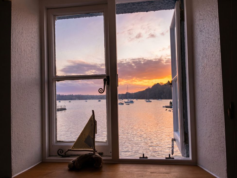 A view through a window showing boats on water at Quay Cottage