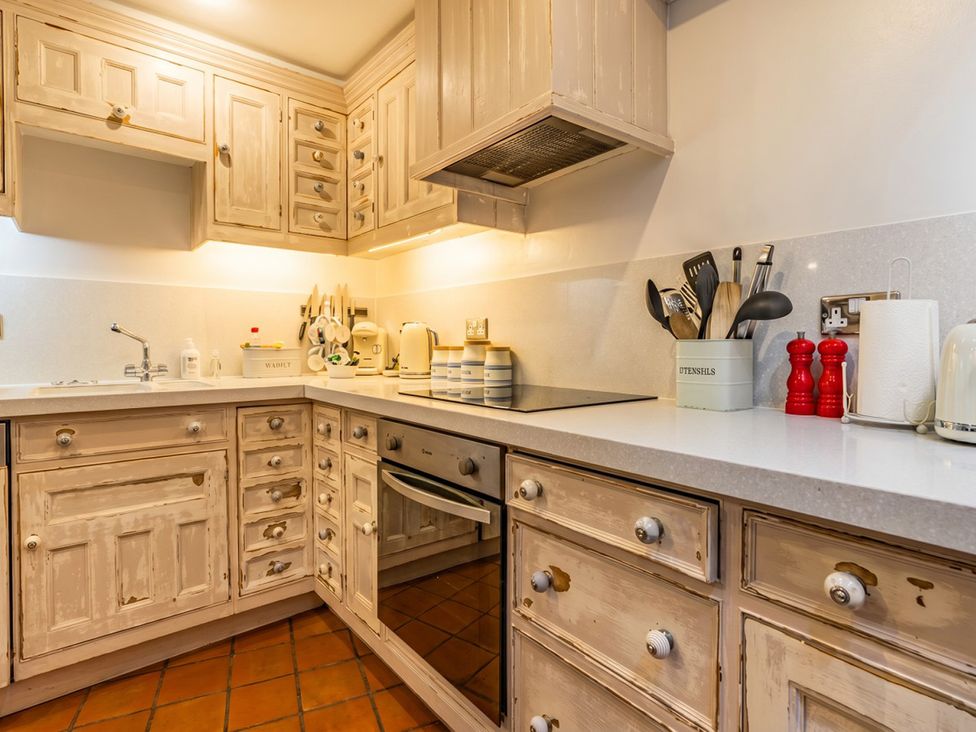 A kitchen with cabinets and countertop at Quay Cottage
