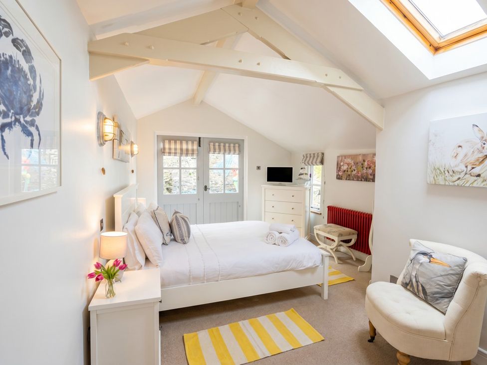 A bedroom with a bed and decorative items at Quay Cottage 