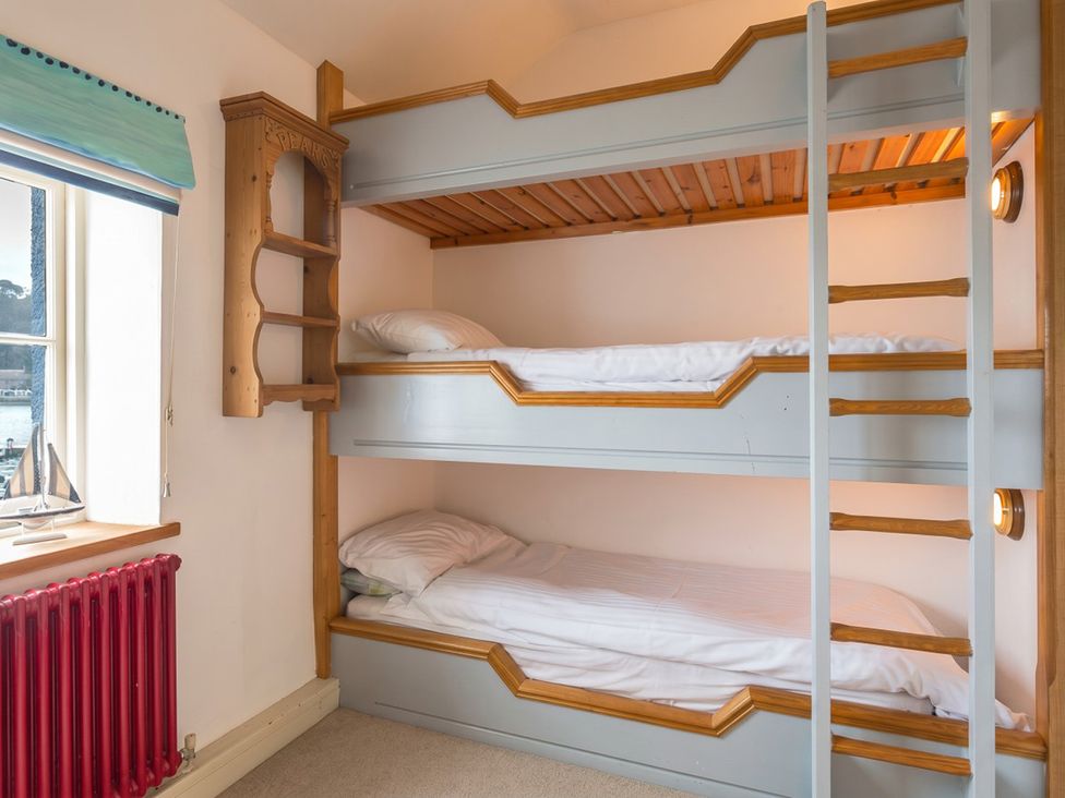 A bunk bed with bedding in a bedroom at Quay Cottage
