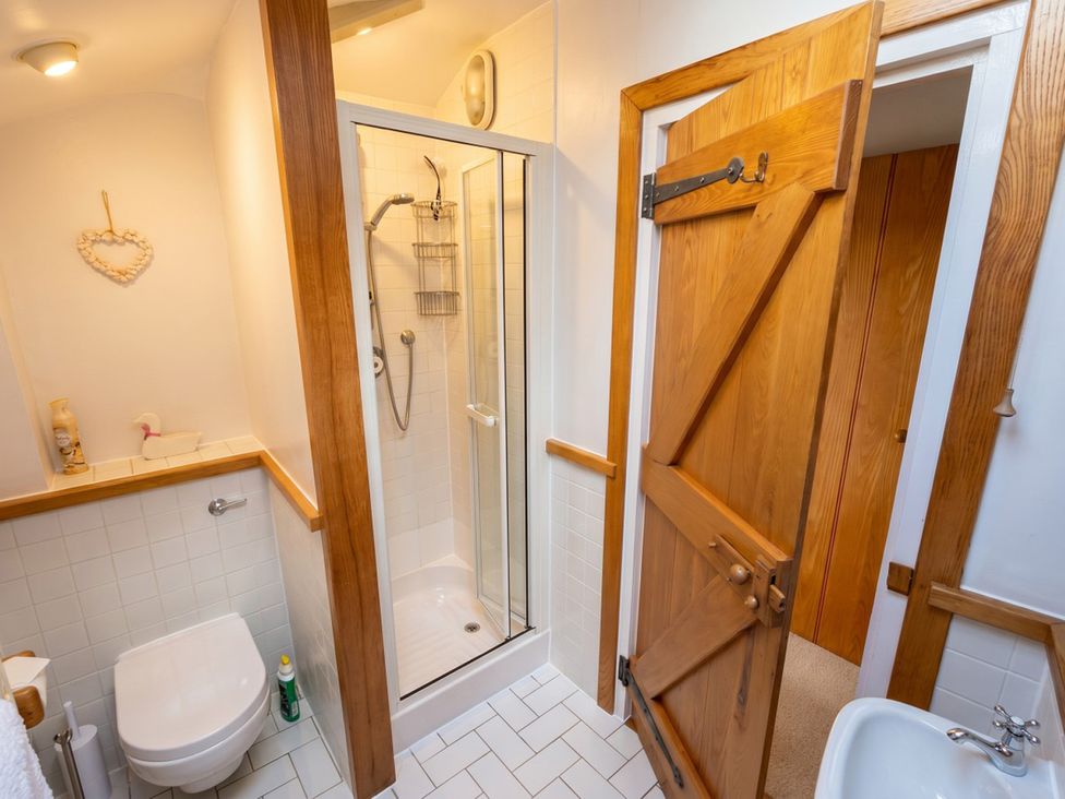 A bathroom with a shower, toilet, and sink at Quay Cottage in 