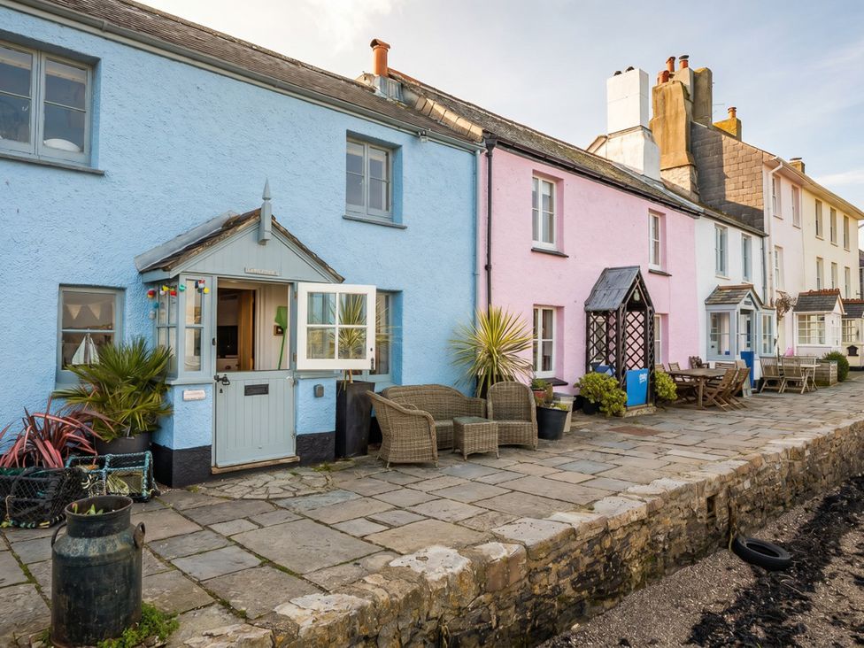 An outdoor area with colorful houses and furniture at Quay Cottage