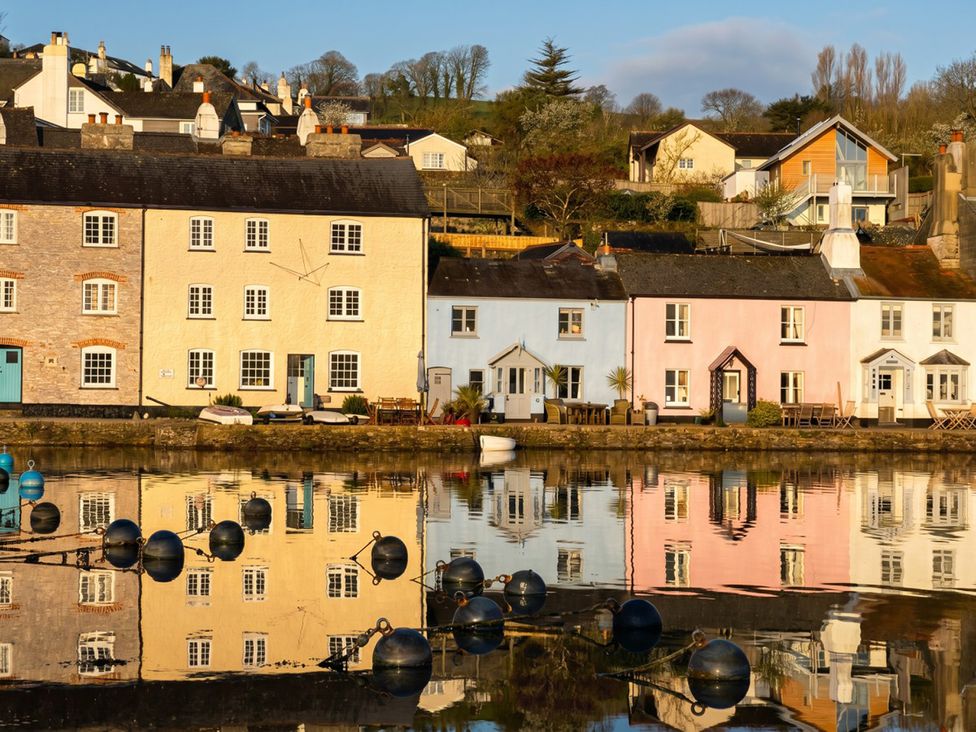 A row of houses with reflections in the water at Quay Cottage in 