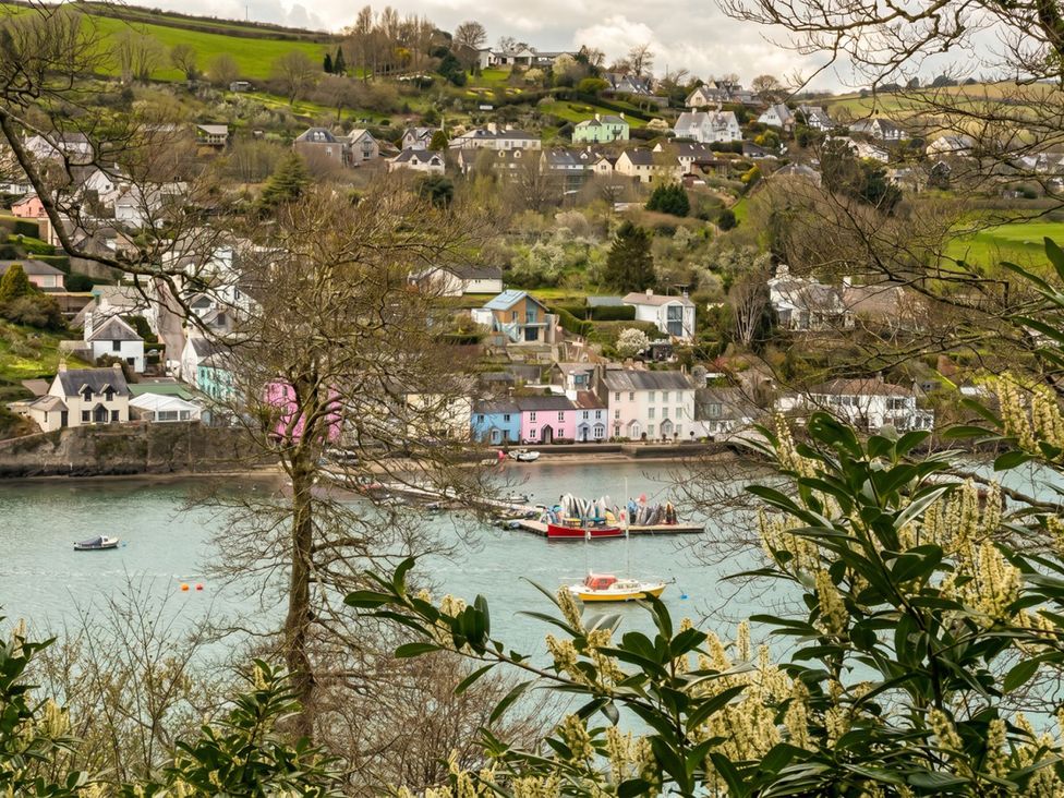 A view of colorful houses along a river with boats at Quay Cottage in 