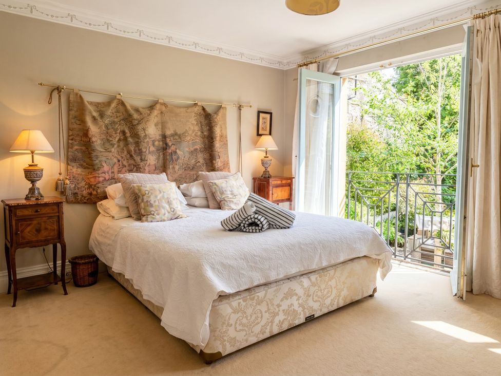 A bedroom with a bed and a balcony at Circus Mews Townhouse