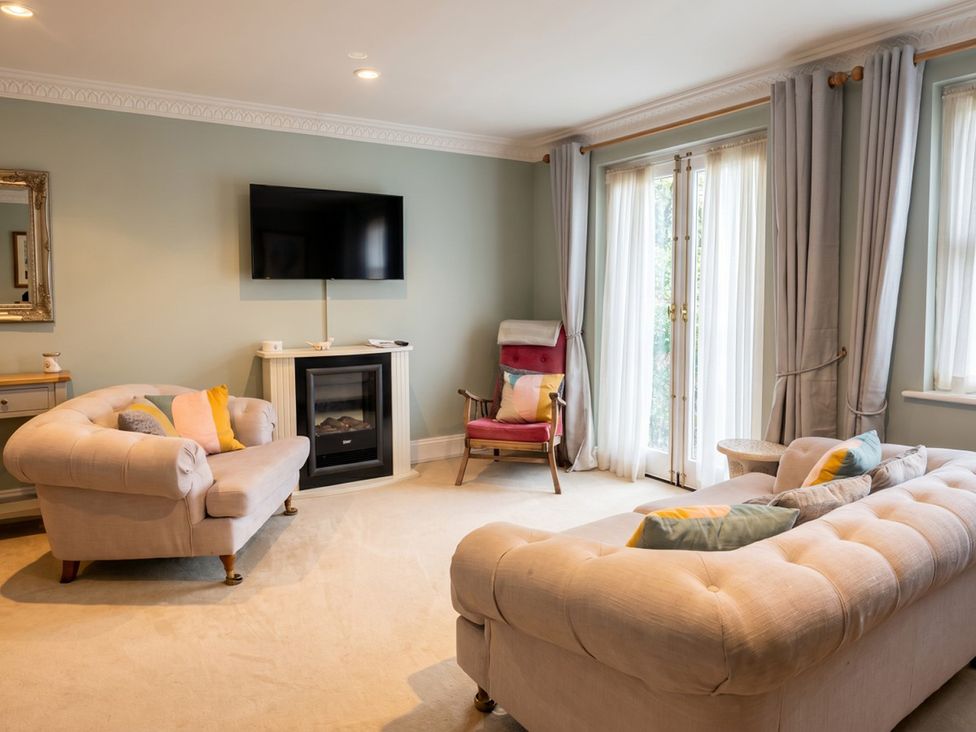 A living room with a sofa and a television at Circus Mews Townhouse