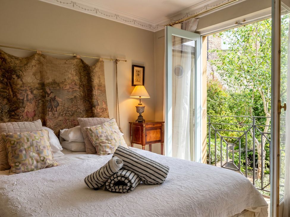 A bedroom with a bed and balcony at Circus Mews Townhouse