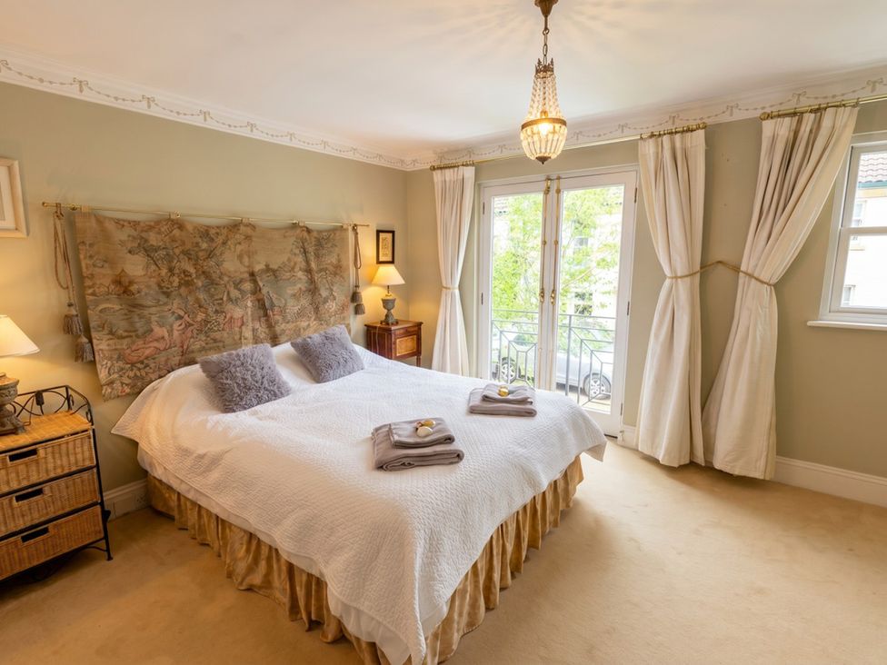 A bedroom with a bed and wall hanging at Circus Mews Townhouse