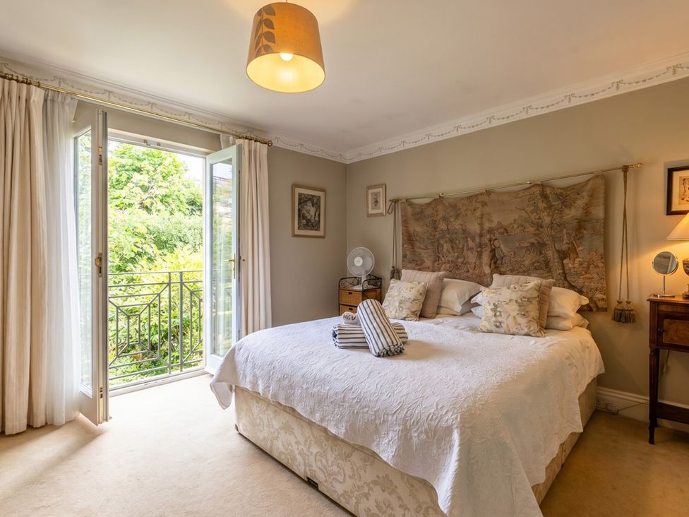 A bedroom with a bed and a balcony door at Circus Mews Townhouse