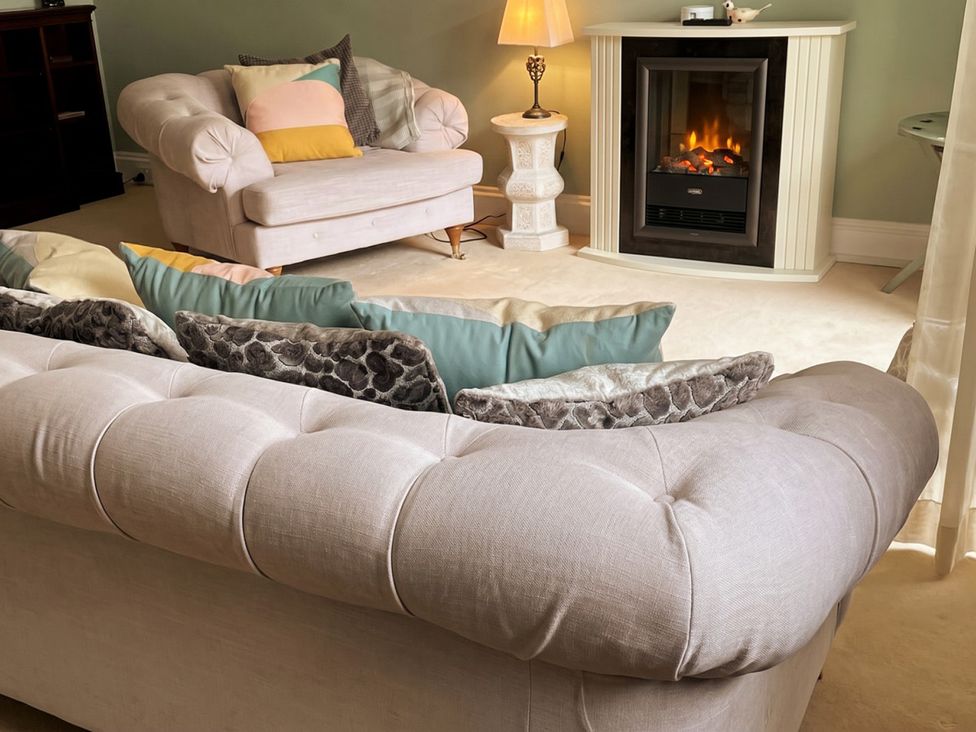 A living room with a sofa and armchair near a fireplace at Circus Mews Townhouse