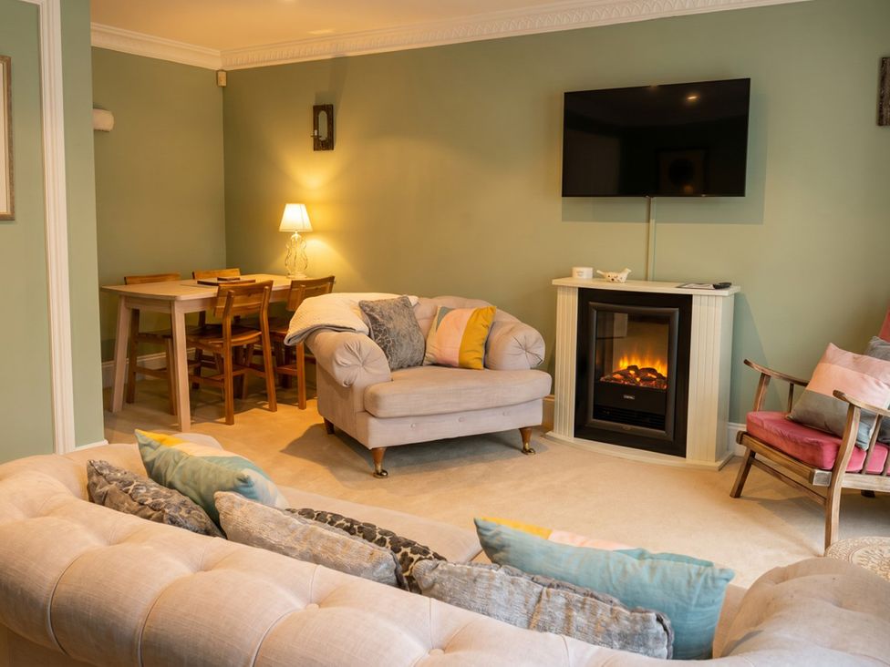 A living room with a sofa and dining table at Circus Mews Townhouse