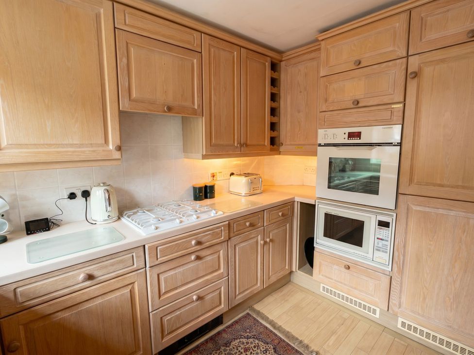 A kitchen with wooden cabinets and appliances at Circus Mews Townhouse