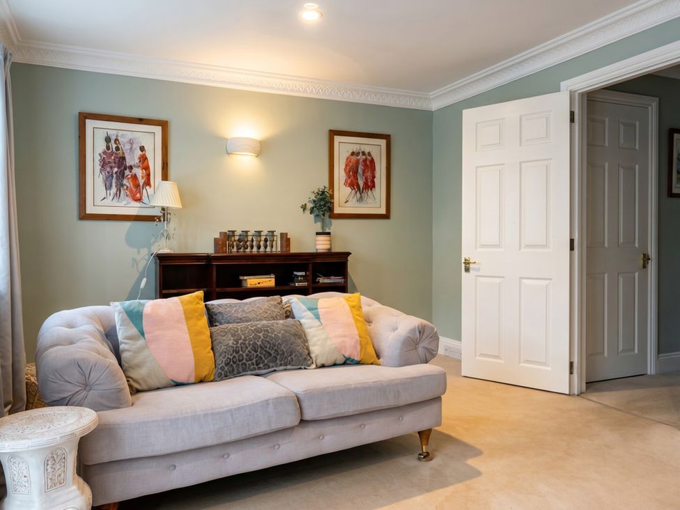 A living room with a sofa and paintings at Circus Mews Townhouse  
