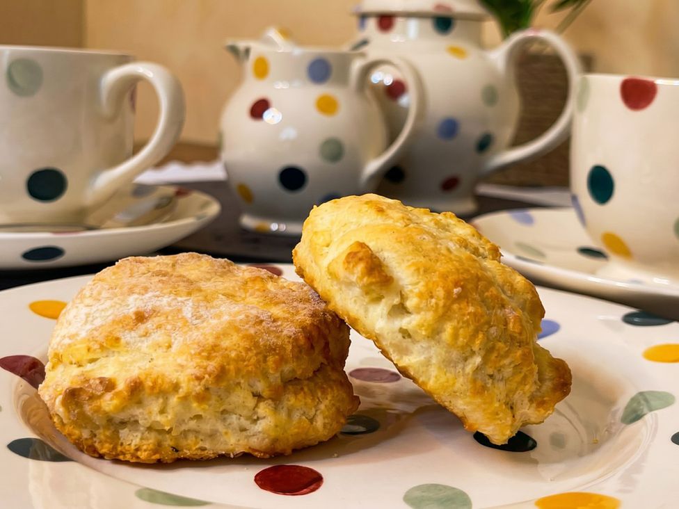 Scones on a plate with colorful tea sets at Circus Mews Townhouse