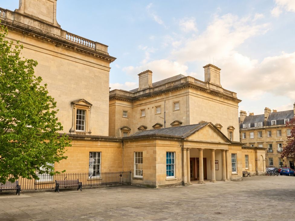 An outdoor view of a building with benches and trees at Circus Mews Townhouse