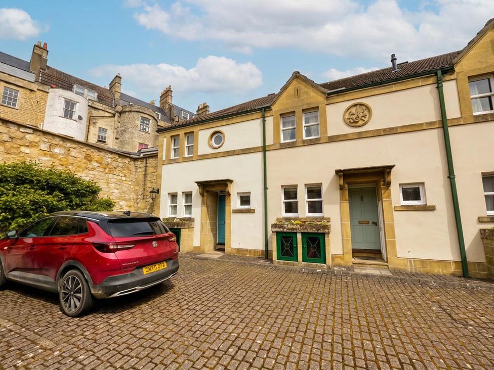 An outdoor area with a red car parked in front of buildings at Circus Mews Townhouse