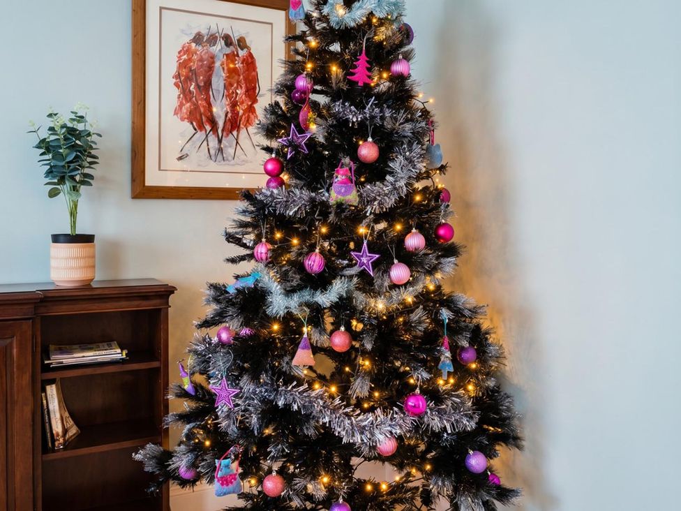 A Christmas tree decorated with ornaments and lights at Circus Mews Townhouse