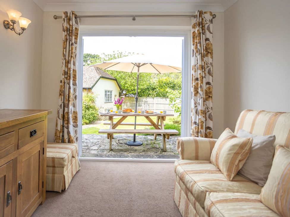 A living room with an open door leading to a patio at The Old Barn in Manchester